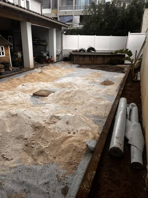 Pose d'un géotextile avant la mise en place d'un lit de sable